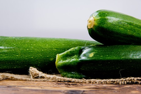 Photo of zucchini on burlap and wooden boardの写真素材