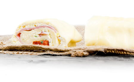 Photo of sliced cheese roll on wooden board with white space for textの写真素材