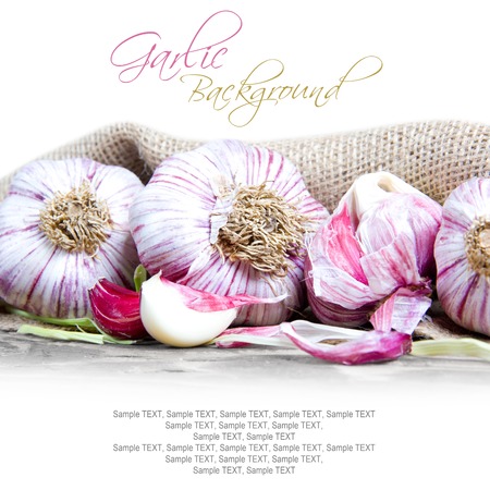 Photo of garlic heads on wooden board with white spaceの写真素材