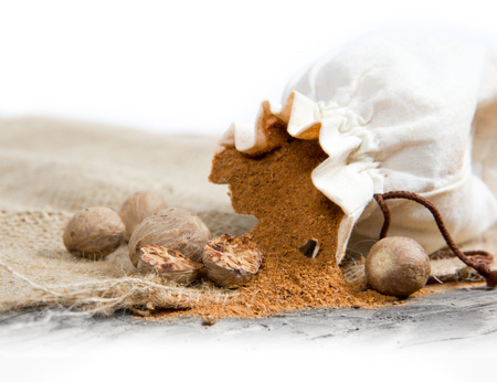 Photo of bag full of nutmeg powder on burlap with white spaceの写真素材