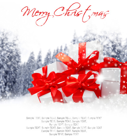 Photo of gifts with colorful ribbons, falling snow and white spaceの写真素材