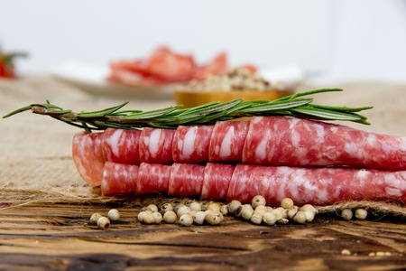 Photo of italian ham with herbs and spice on wooden boardの写真素材