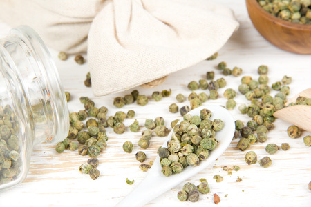 Photo of bowls full of green pepper seeds and powder on white wooden surfaceの写真素材