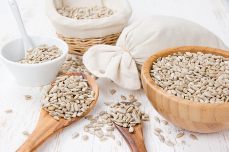Photo of bowls full of sunflower seeds on white wooden surfaceの写真素材