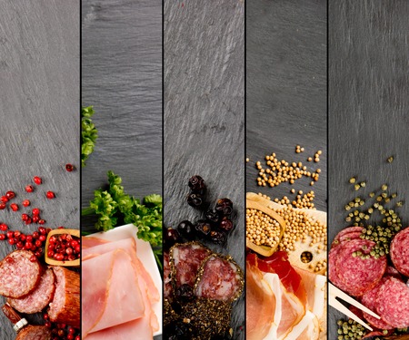 Top view of ham and salami mix with herbs and pepper spice on gray slate surfaceの写真素材
