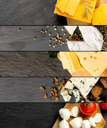 Top view of various kinds of cheese abstract mix with spice and herbs on gray slate surfaceの写真素材