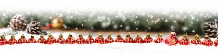 Wide horizontal composition of red Christmas Ball group on spruce and coneの写真素材