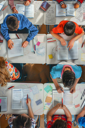 Top view of classroom with desks and school children sitting and studying.の素材