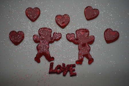 Two cupids surrounded by read hearts, white background.の写真素材