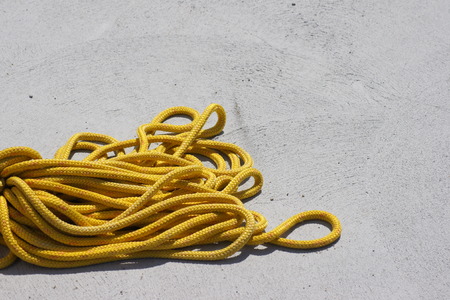 Yellow rope lying loosely on a pier.の写真素材