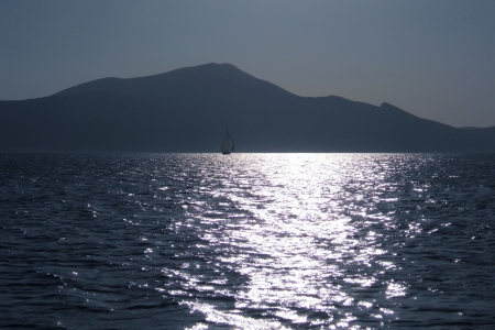 Sea sunset with a sailing boatの写真素材