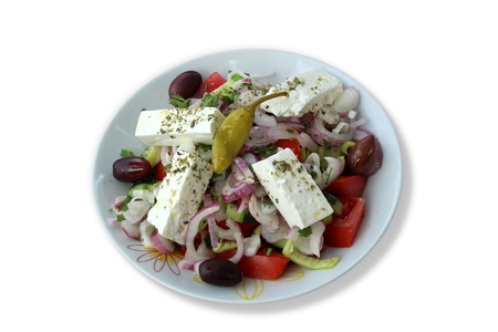 Real greek salad in a white plate isolated on white backgroundの写真素材