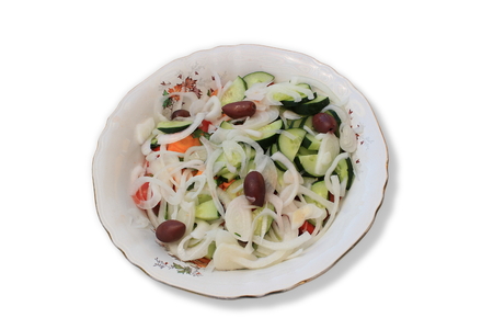 Real greek salad in a white plate isolated on white backgroundの写真素材