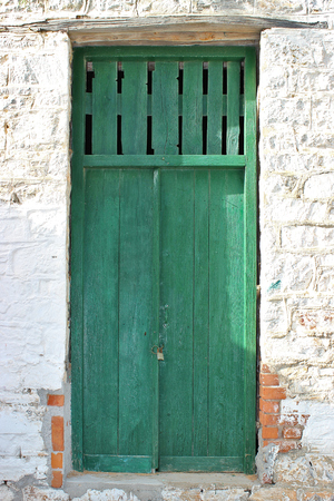 Weathered green front door of an old stone house at south Pelion, Greeceの写真素材