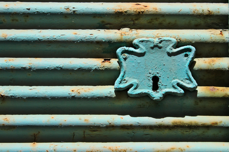 Old blue weathered steel roll shutter lockの写真素材