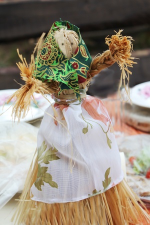 Self-made doll from straw in an apron and a scarfの写真素材