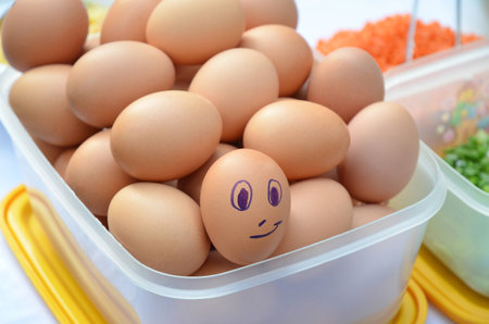 Egg with smiley face in the pile of chicken eggs