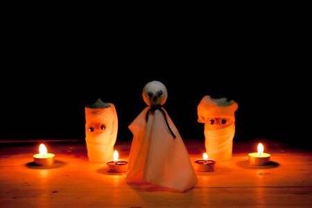 Halloween. DIY. Mummy creative idea from toilet tube recycle, and candle on table with black background.の写真素材