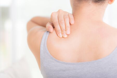 Closeup asian woman neck and shoulder pain and injury. Health care and medical concept.
