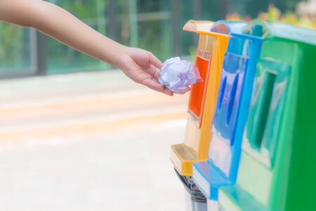 Closeup a child hand throwing crumpled paper in recycling bin. World Environment Day concept. Copy space for advertisers.の写真素材