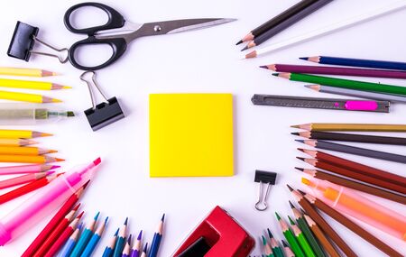 Backpack with different colorful stationery on white table background. Back to school concept.