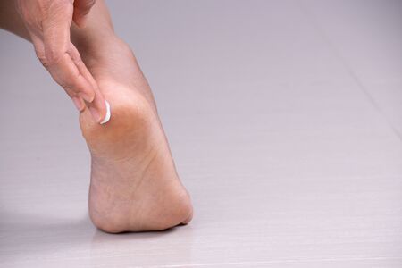Healthcare concept. Closeup shot of young woman foot applying moisturizing foot cream.の写真素材