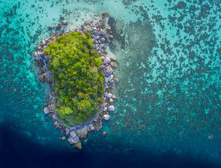Aerial view of lonely rocky island in the ocean