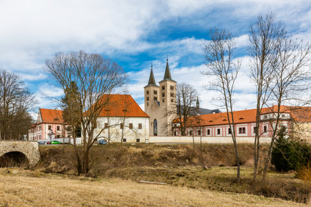 Milevsko, Czech Republic - February 22 2020: View of the Premonstratensian Monastery from 12th century and two towers of the church of Annunciation of Virgin Mary. Blue sky and white clouds.のeditorial素材