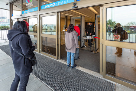 Prague, Czech Republic - March 26 2021: Entrance into the building of the Metropolitan vaccination center against COVID-19 at Prague Congress center. People waiting outside in a queue.のeditorial素材