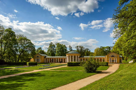 Marianske Lazne, Czech Republic - June 1 2021: The Ferdinand spring pavilion, a yellow building, standing in a park with green lawn and trees. Sunny day with blue sky and clouds.のeditorial素材