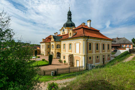 Nebilovy, Czech Republic - September 9 2018: View of the castle with yellow facade and red roof. Sandy path, green grass in front of the building.のeditorial素材