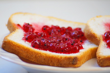 A plate with some bread with jam for breakfast on the background
