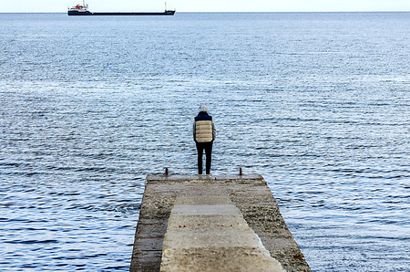man on the coast of the Black Sea and the ship on the horizon.の写真素材