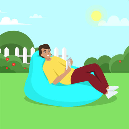 Young man sits on bean bag with gadget. Work and chill. Modern flat vector illustrationのイラスト素材