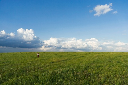 The girl with a bunch of flower specifies a cloud in the skyの写真素材