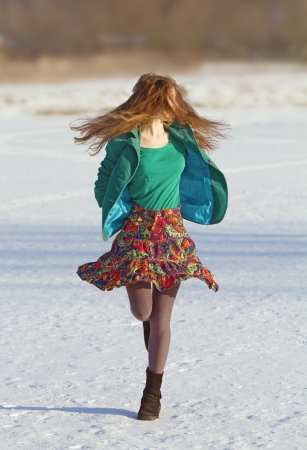 Girl jogging in snowy fieldの写真素材
