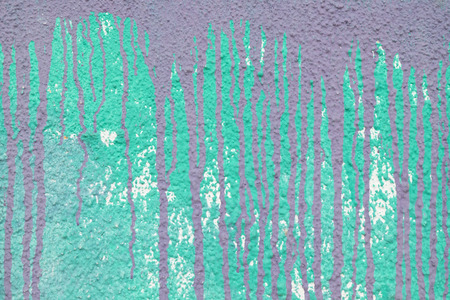streaks of purple paint on a green wallの写真素材