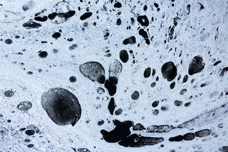 Mix of a white and black paint, closeup.