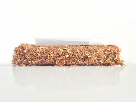 Hand rolling tobacco with a rolled cigaretteの写真素材
