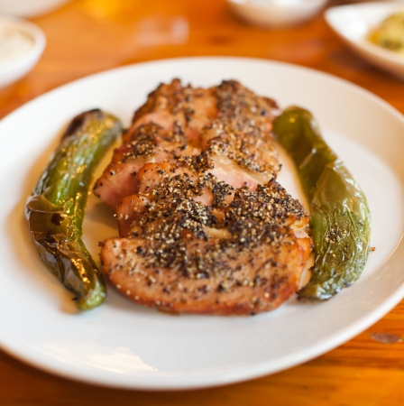 Dish of sliced smoked goose breast with pepper and grilled green peppersの写真素材