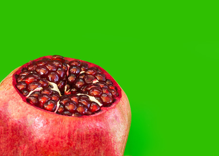 Open Pomegranate with seeds on green の写真素材