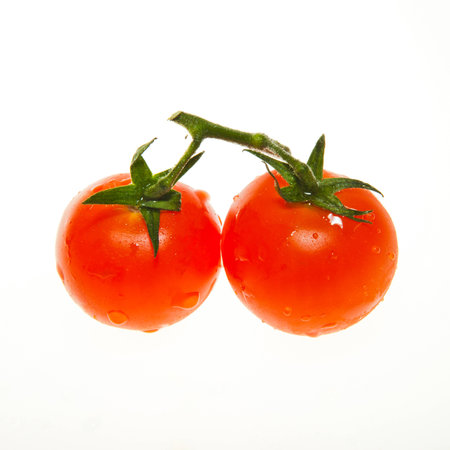 Two red cherry tomato with green stem and water dropsの写真素材