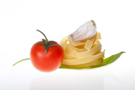 Arrangement of Tagliatelle pasta cherry tomato garlic and basilの写真素材