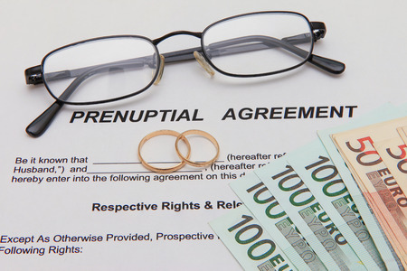 Prenuptial Agreement with wedding rings and euro notesの写真素材