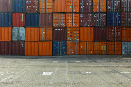 Various brands and colors of shipping containers stackedのeditorial素材