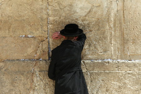 Orthodox Jewish man pray at the western wall. The western wall is an exposed section of ancient wall situated on the western flank of the Temple Mount.のeditorial素材