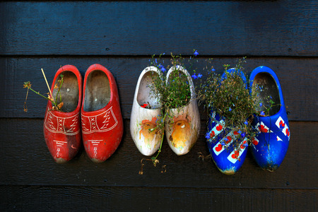 Colorful wooden clogs on dark wooden panelsの写真素材
