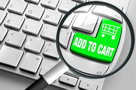 Computer keyboard with green add to cart button and magnifying glassの写真素材