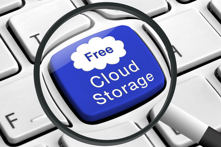 Computer keyboard with blue cloud storage button and magnifying glassの写真素材