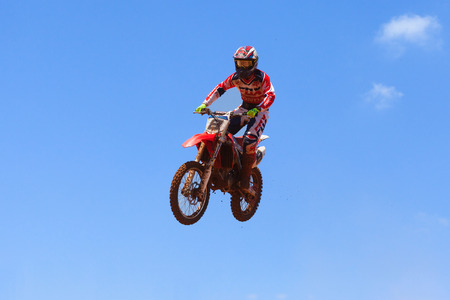 Motocross rider and bike clearing a tabletop jump during the final heat of the raceのeditorial素材